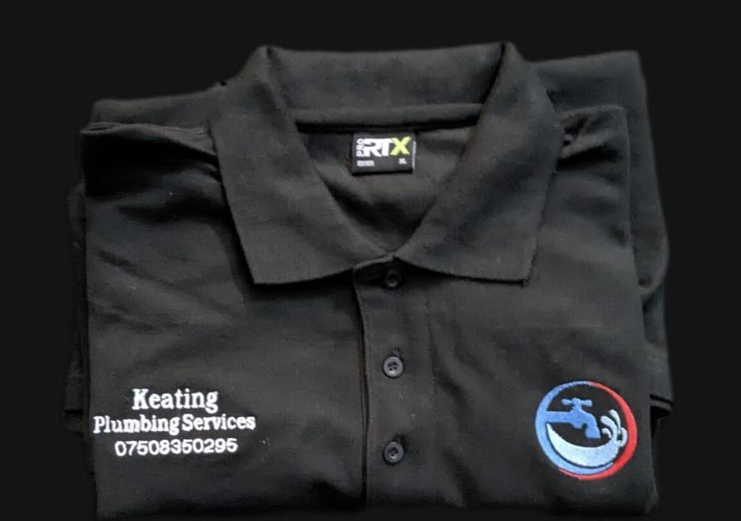 Close-up of Keating Plumbing Services polo shirt - company name and phone number embroidered on the left chest, logo on the right chest